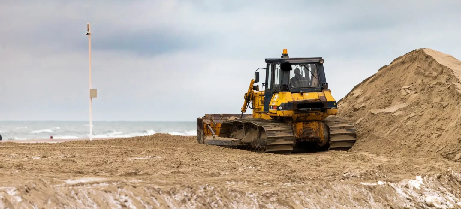 Bulldozer on beach for coastal development and erosion control