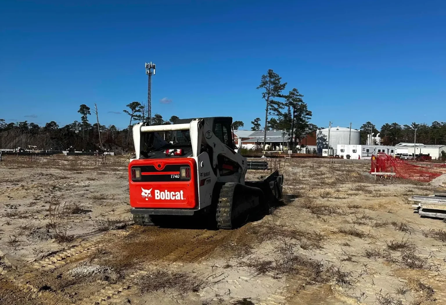 Preparing soil for hydroseeding application using a Bobcat skid steer.