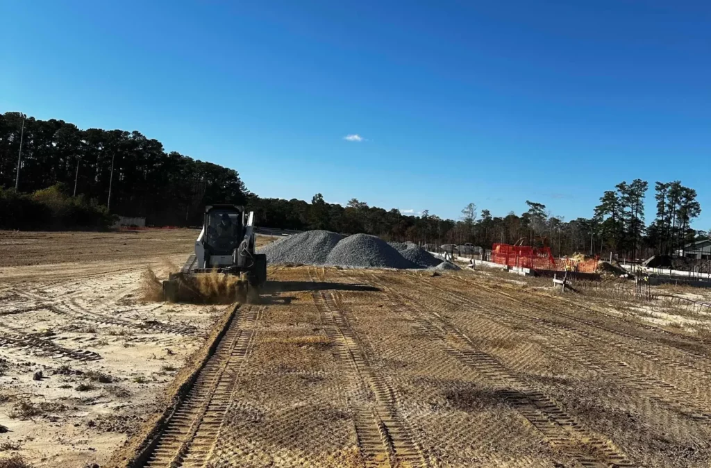 Preparing soil for hydroseeding application using a Bobcat skid steer.