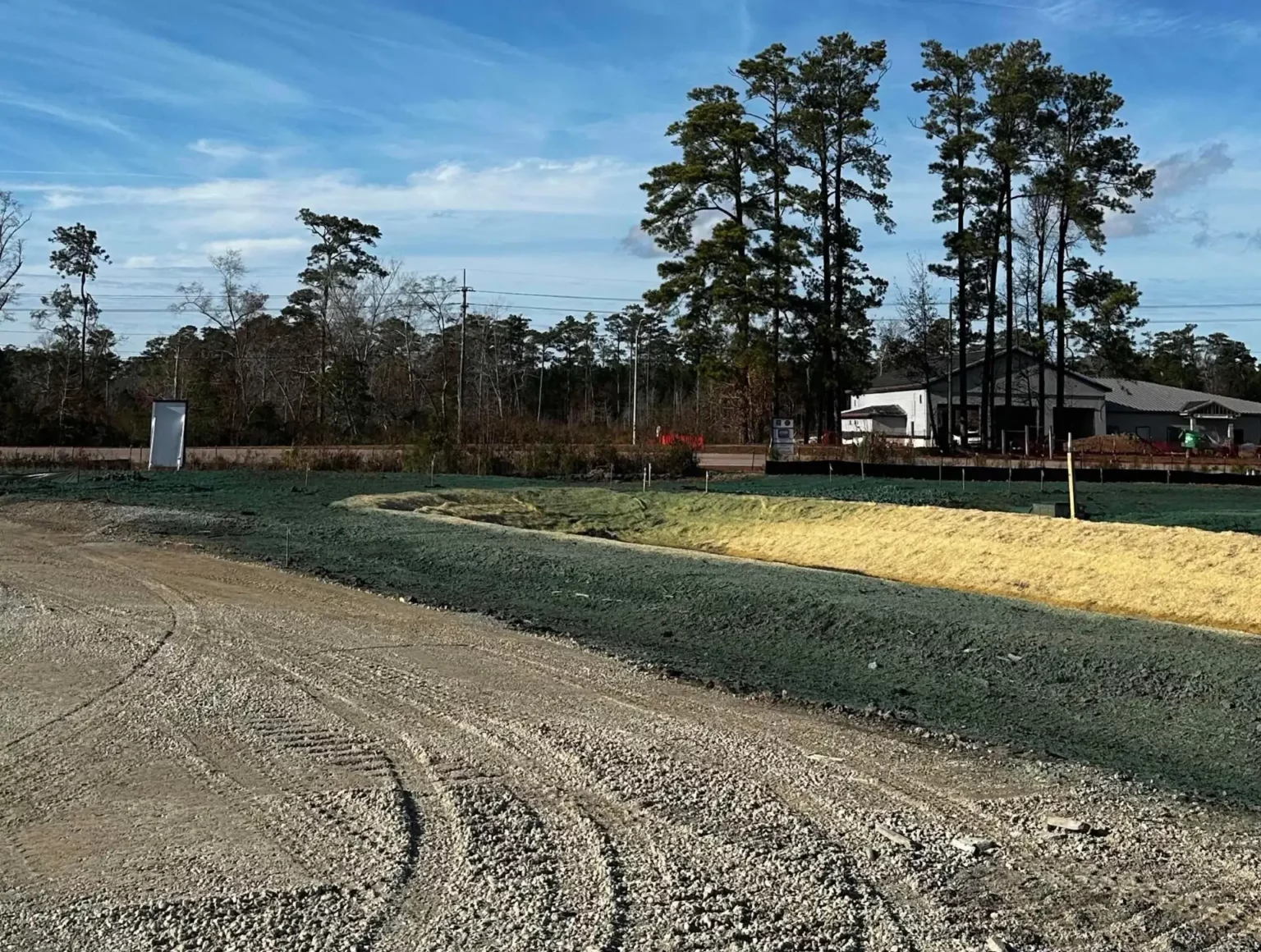 Stabilizing sediment basin slopes using hydroseeding and erosion control matting to prevent erosion and support vegetation growth.