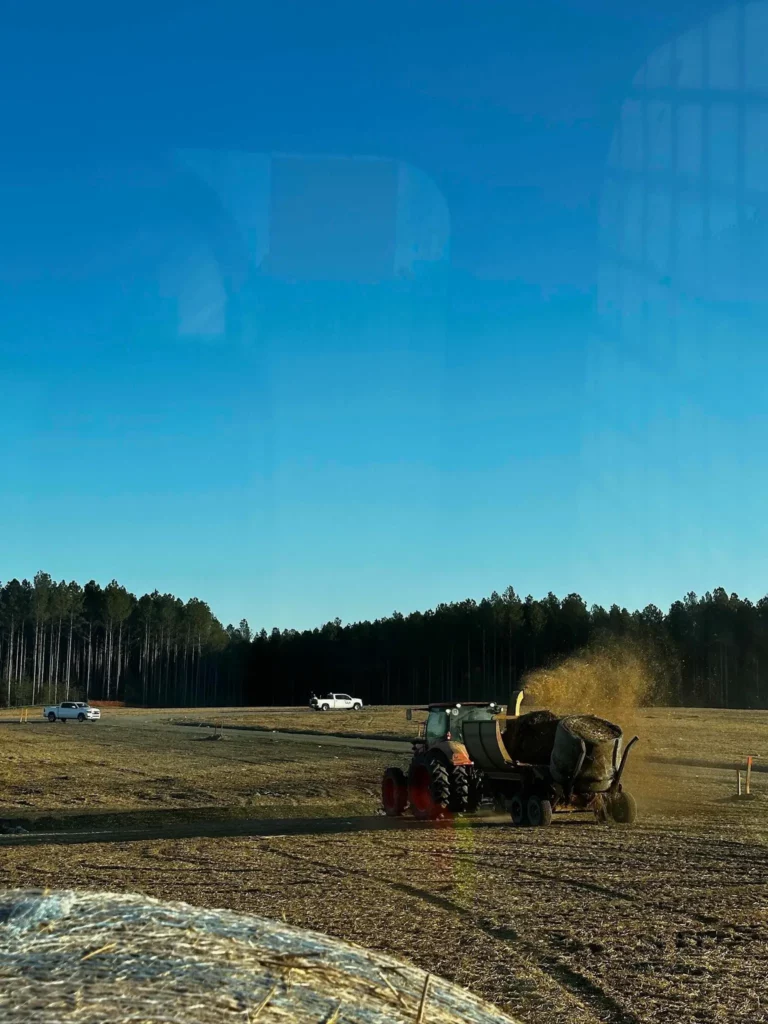 Spreading straw mulch over newly seeded soil with our haybuster to help stabilize the surface, retain moisture, and promote vegetation.