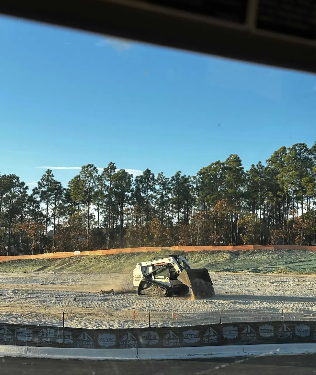 Site preparation in progress: smoothing ruts and raking to create a uniform seed bed ahead of hydroseeding application.