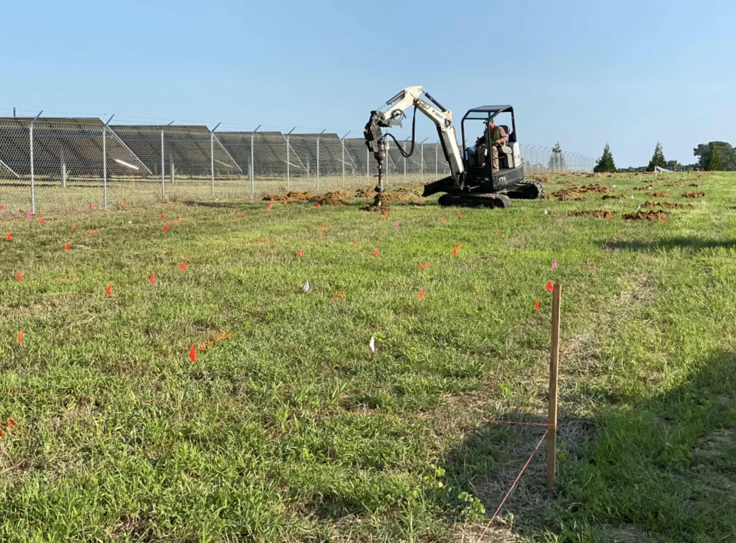 A mini excavator with an auger attachment was used to dig precise planting holes for the new trees and shrubs, ensuring efficient and consistent installation.
